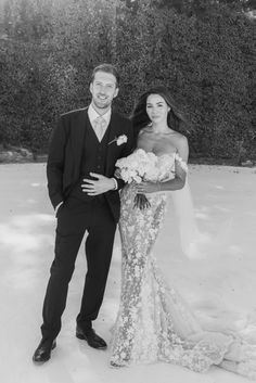 a bride and groom standing in the snow