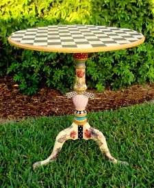 a table that is in the grass with a checkerboard design on it,