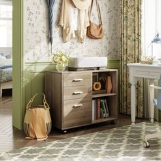 a room with green walls and floral wallpaper on the walls, including a dresser