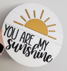 someone is holding up a sign that says you are my sunshine on the side of a wall