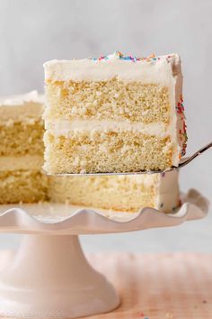 a slice of cake with white frosting and sprinkles