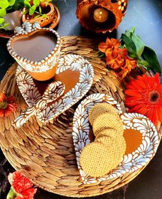 two plates with cookies and dipping sauces on them next to some orange flowers in the background