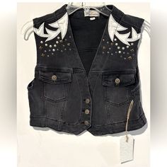 This Austin Landing Vest Is A Must-Have For Any Fashion-Forward Woman. The Black Denim And Leather Patches Give It A Edgy, Yet Chic Look That Is Perfect For Any Occasion. With A Button Closure And Studded Accents, This Vest Is Both Stylish And Functional. It Is Made Of A Cotton Blend Fabric And Lined With 100% Cotton, Making It Comfortable And Easy To Care For. This Vest Is Perfect For Summer, Fall, And Spring, And Is Available In A Women's Size L. The Biker Style And Cowboy/90s Theme Add A Touc Summer Black Denim Vest For Streetwear, Spring Black Denim Vest, Edgy Streetwear Vest For Spring, Black Punk Vest For Spring, Black Sleeveless Denim Vest For Spring, Black Denim Casual Vest, Casual Black Denim Vest, Trendy Black Denim Vest For Streetwear, Black Denim Vest For Fall