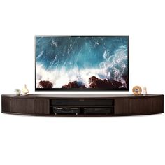 a flat screen tv sitting on top of a wooden entertainment center in front of a white wall