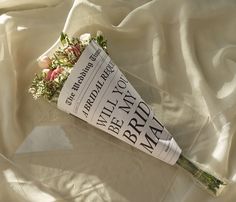 a bouquet of flowers laying on top of a white sheet covered bedding with the words bridal