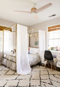 a bedroom with a bed, desk and ceiling fan