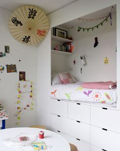 a room with white furniture and lots of decorations on the walls, including a bed