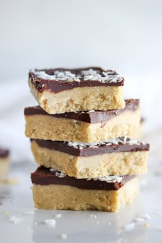 three pieces of chocolate and coconut bars stacked on top of each other