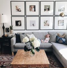 a living room with pictures on the wall and a couch in front of a coffee table