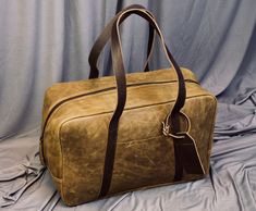 "Elevate your travel style with our exquisite Handcrafted Leather Travel Overnight Bag a fusion of elegance, durability, and wanderlust. This leather bag has a unique style of long handles that make this bag more stylish and easy to carry. LEATHER COLOUR: ITALIAN GOLD CERATO Size: 18\"x12\"x6\"(LxHxW) FREE Personalization on the Leather tag. Key Features: Our artisans handcraft each travel bag with precision and care, resulting in a masterpiece that stands the test of time. Every stitch is a tes Travel Satchel With Leather Lining, Rectangular Travel Satchel With Waxed Finish, Travel Shoulder Bag Briefcase With Waxed Finish, Rectangular Weekender Bag With Waxed Finish For Everyday Use, Waxed Finish Shoulder Briefcase For Travel, Leather Rectangular Briefcase For Trips, Rectangular Leather Duffle Bag, Rectangular Leather Briefcase For Trips, Leather Rectangular Weekender Bag For Travel