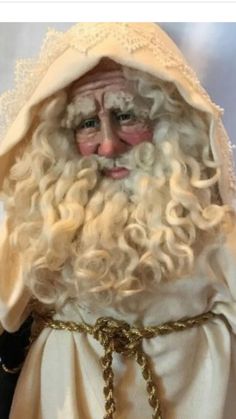 a close up of a statue of santa claus wearing a white robe and gold chains