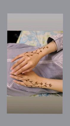 a woman's hands with henna tattoos on them