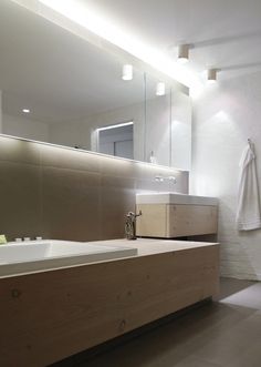 a bathroom with a sink, mirror and bathtub in it's center area