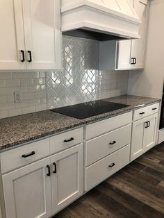 a kitchen with white cabinets and granite counter tops