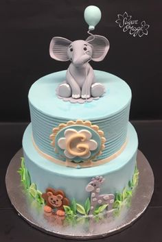 a blue cake with an elephant and giraffe on top