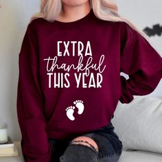 a woman with blonde hair wearing a red sweatshirt that says extra thankful this year