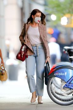 a woman walking down the street wearing a face mask