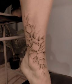 a woman's foot with a flower tattoo on her left side and right leg