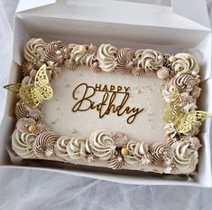 a birthday cake in a white box with gold butterflies on the top and writing happy birthday