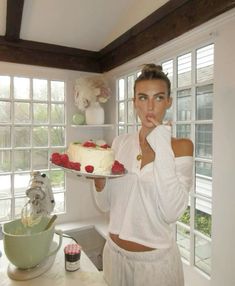 a woman holding a cake in front of her face