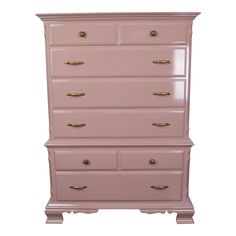 a pink dresser with gold handles on it's top and bottom drawers, against a white background