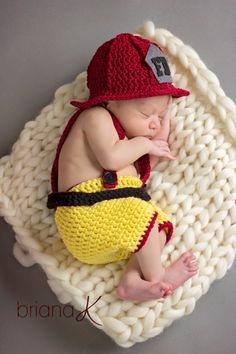 a newborn baby wearing a fireman hat and diaper