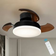 a ceiling fan that is mounted on the wall with a remote control in front of it