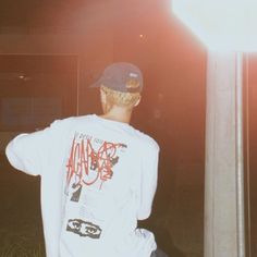 a young man sitting on top of a pole next to a street light at night