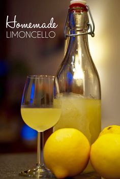 two lemons sit next to a bottle and glass on a table with the words homemade limoonocello