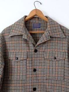 A 1960s vintage Pendleton plaid check wool coat. The men's jacket features a beige, gray, and orange plaid pattern. It has four pockets, and black button closures. • Pendleton Woolen Mills• pure virgin wool• gray, orange, and beige plaid• four pocket• black button closureCONDITIONIn good condition with wear consistent with age and use. MARKED SIZE: LMEASUREMENTSBust:  48"  ...  121.9 cmLength:  31"  ...  78.7 cmShoulders:  20"  ...  50.8 cmSleeves:  34"  ...  86.4 cmOuter Sleeve: 23.5"  ...  59. Check Jacket, Pendleton Woolen Mills, Beige Plaid, Checked Jacket, Orange Plaid, Plaid Coat, Black Button, Vintage 60s, Wool Coat