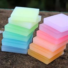 a stack of multicolored soap blocks sitting on top of a stone floor next to each other