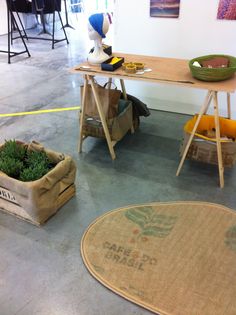 a table with two baskets on top of it next to a rug and other items