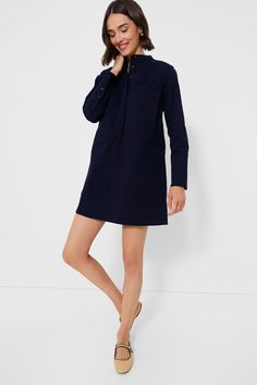 Elevate your capsule wardrobe with the Navy Twill Denim Wellington Dress. This mini is constructed from a structured organic cotton, featuring a crisp stand collar, front button placket with chest patch pockets, and long sleeves with long cuffs offering polished and elegant look. Exquisitely chic, we are pairing this number with everything from sneakers to sandals. Stand collar Long sleeves with long button cuffs Concealed front button placket Center back pleat Front patch pockets Side seam pock Casual Dresses With Stand Collar For Workwear, Business Casual Collared Cotton Dress, Fitted Cotton Shirt Dress For Fall, Fall Cotton Shirt Dress, Cotton Shirt Dress With Button Cuffs For Work, Modern Long Sleeve Shirt Dress For Work, Casual Navy Shirt Dress For Work, Fall Workwear Cotton Shirt Dress, Fall Cotton Shirt Dress For Work