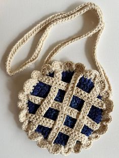 a crocheted bag with blue and white squares on the front, hanging from a string