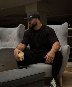 a man sitting on a couch holding a cup