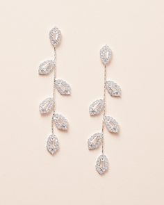 two pairs of earrings with leaves hanging from them