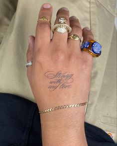 a woman's hand with two different rings on it and the words happy new year written in cursive writing