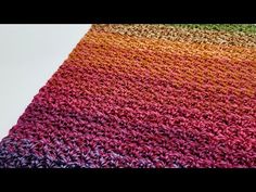 a multicolored crocheted blanket on top of a table