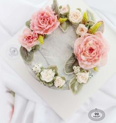 a cake decorated with pink flowers and leaves