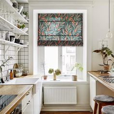 the kitchen is decorated with plants and pots on the windowsill, along with an open window sill