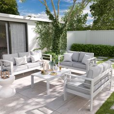 an outdoor living area with white furniture