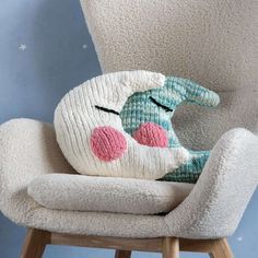 a stuffed animal sitting on top of a white chair next to a blue wall with stars