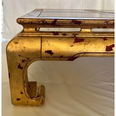 an old gold painted desk with a marble top