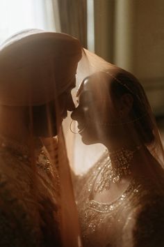 two women standing next to each other in front of a window with sunlight streaming through them