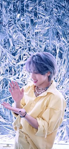 a woman standing in front of a wall with ice on it's sides and holding her hands out