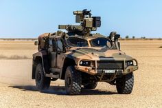 an army vehicle driving through the desert with radars on it's back end