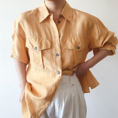 Vintage button down blouse. Light and comfy, perfect for a summer day! It is hard to describe the color accurately, somewhere between orange and yellow, or yellow-ish orange color.  Excellent vintage condition, few tiny spots on right sleeve as shown in detail picture.  Material: 100% silk.  label size 14. Model is 5'5'', 128 lbs, usually US size 5 Flat measurements: bust: 22'' (44'' around) length: 29'' Follow us on Instagram (oldgemvintage) for more choices! Please ask me about international c Summer Orange Button-up Top, Silk Duster, Casual Orange Button-up Blouse, Vintage Orange Button-up Tops, Cheap Orange Button-up Blouse, Orange Button-up Shirt With Pockets, Blouse Silk, Boyfriend Style, Vintage Button