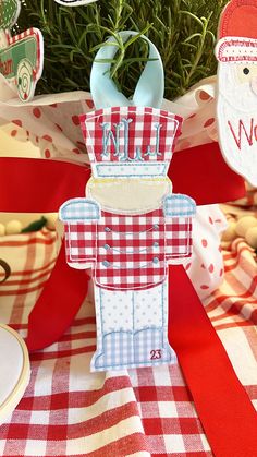 a red and white checkered table cloth with an ornament shaped like a building