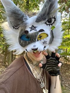 a woman wearing a wolf mask and holding up her mitt in front of her face