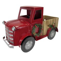 an old fashioned red truck with a wreath on the front and side door is shown